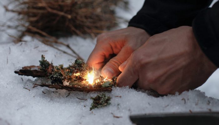 Man Lighting A Fire In A Snowy Evening