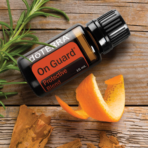 On Guard oil blend bottle beside an orange peal and rosemary sprig
