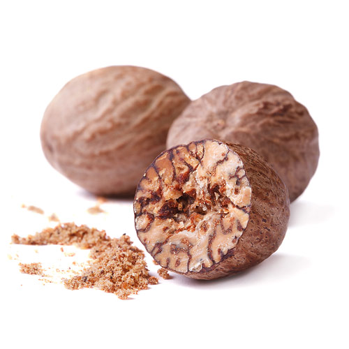 Whole and crushed nutmegs on white background