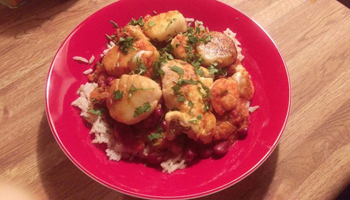 Beans and rice with seafood in red bowl